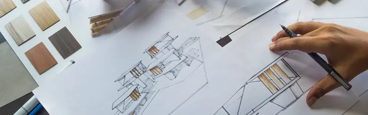 Architektin zeichnet an einem Gebäudeentwurf neben Materialmustern