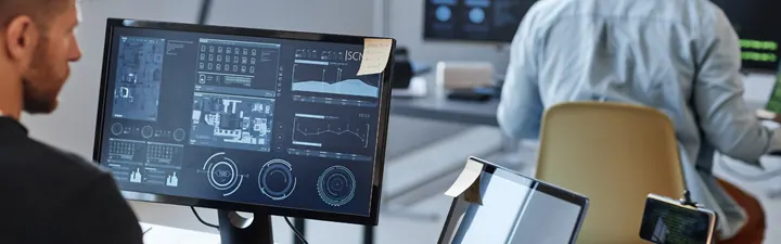 Entwickler vor Monitoren mit Auswertungen und Dashboards