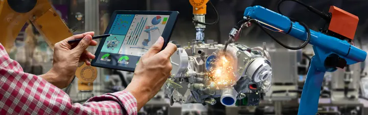 Fachkraft steuert Fertigungsroboter über ein Tablet